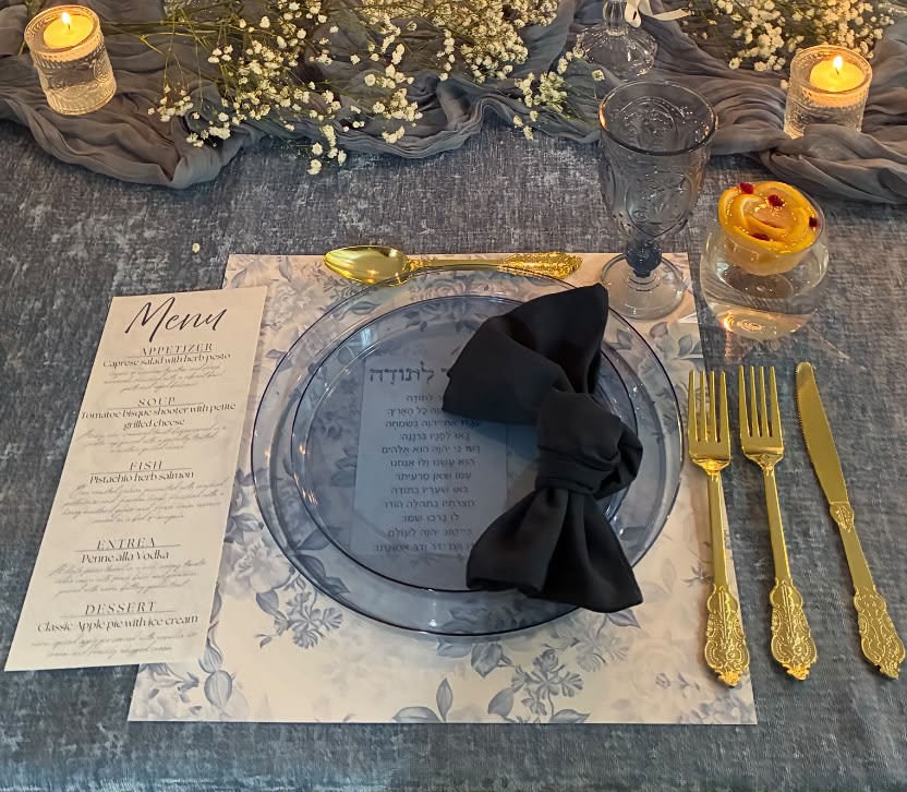 A refined Tied with a Bow tablescape in soft blue tones with florals, candles, and elegant place settings
