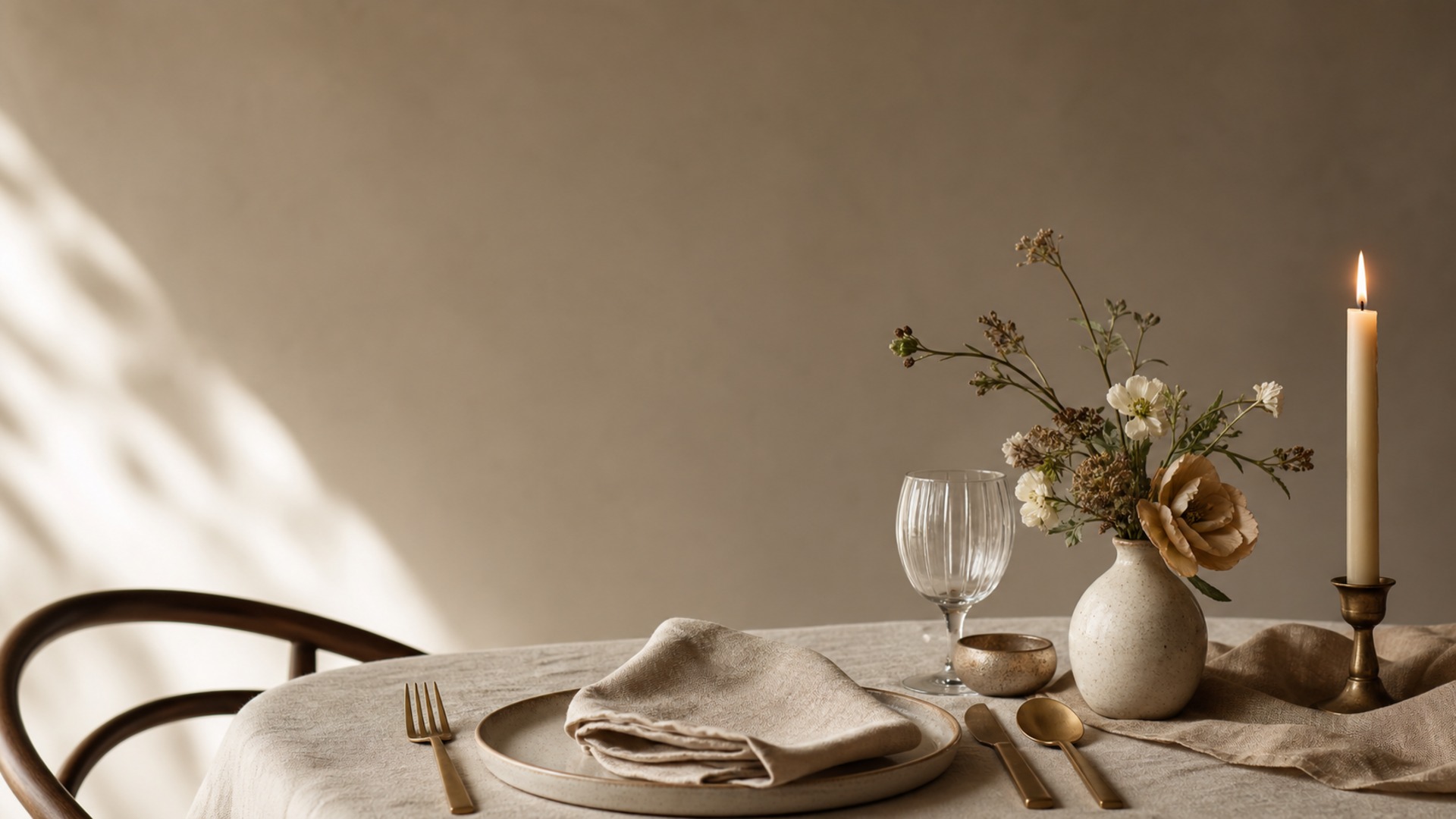 A beautifully layered napkin, cutlery, and place setting under warm candlelight